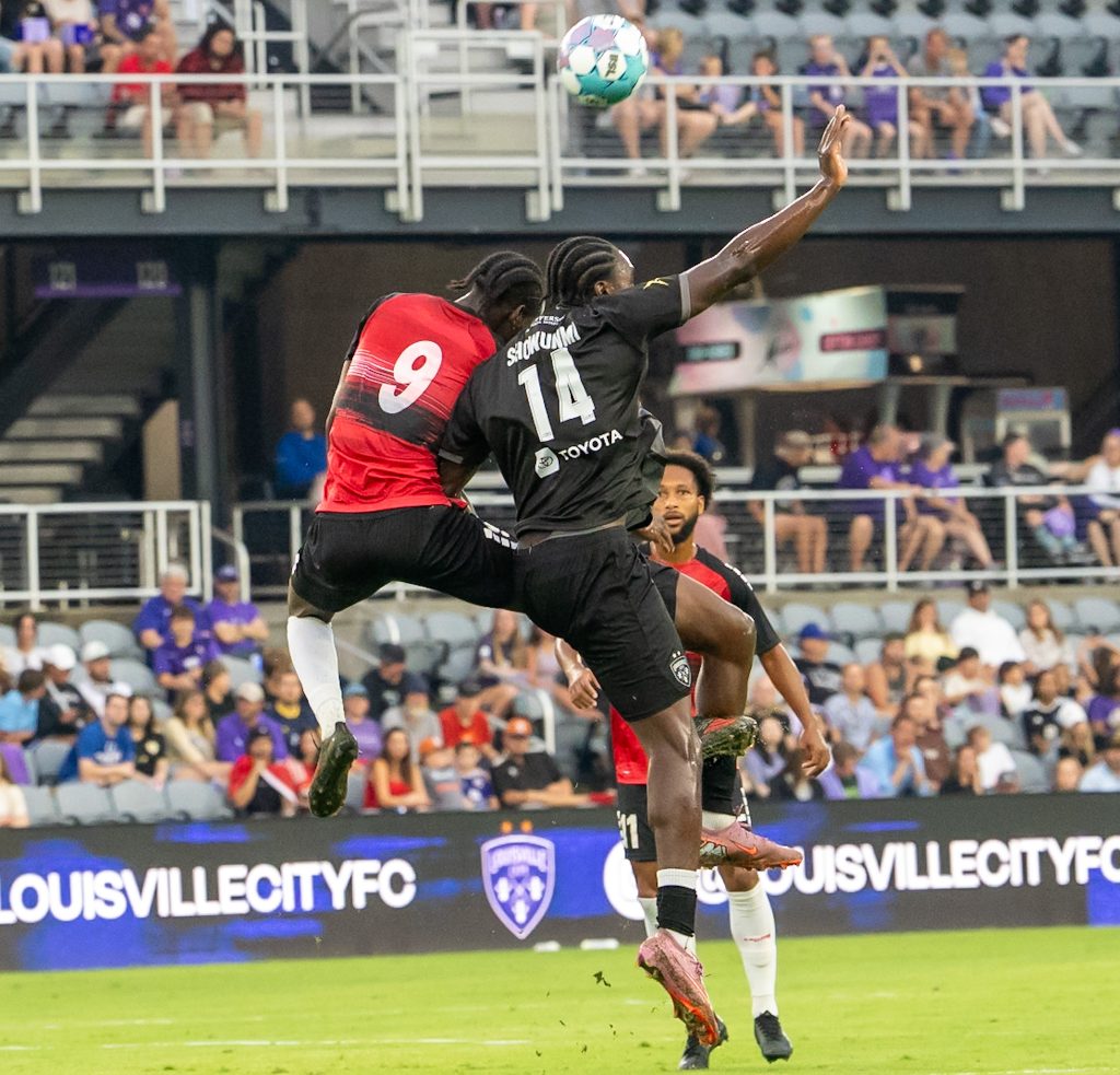 Mid air battle between Trinidad and Tobago's defensive line and Louisville City's midfield