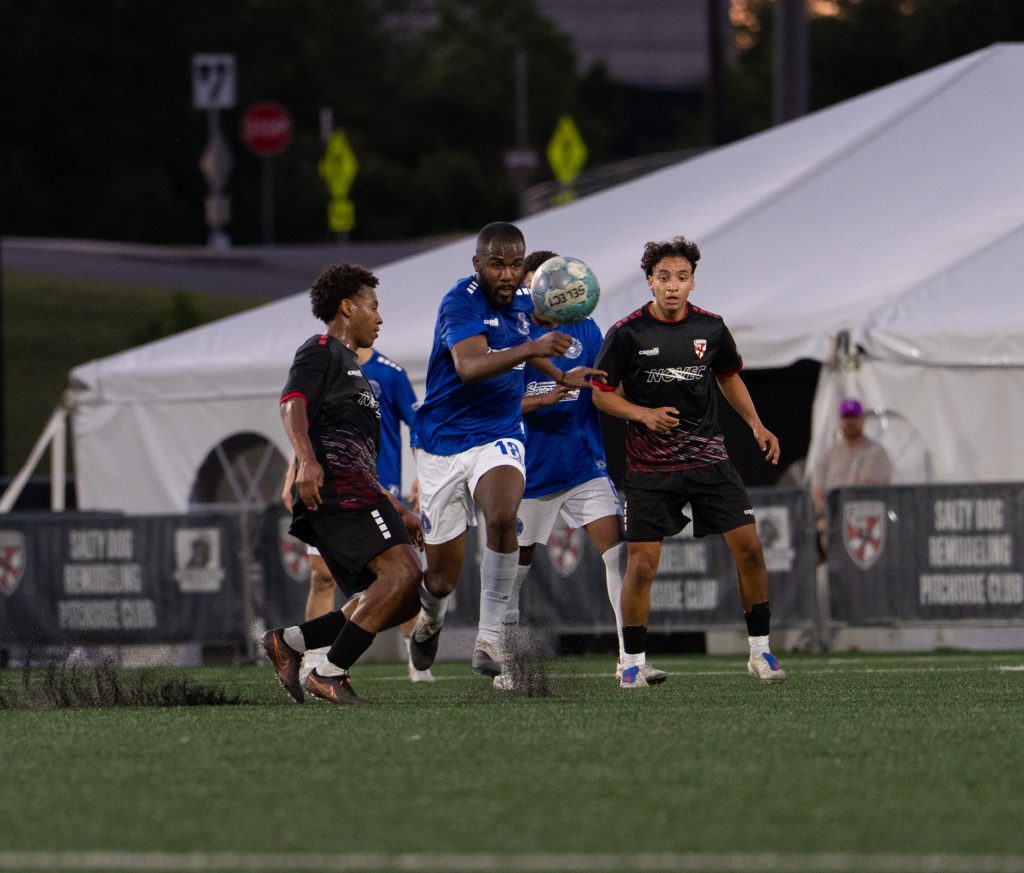 Loudoun United FC 2 player controls the ball under pressure from a Virginia Marauders defender.