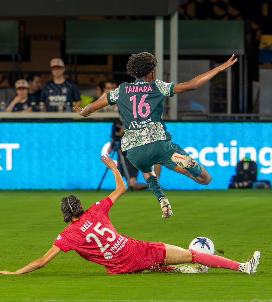 Washington Spirit forward skips over a sliding tackle from a NC Courage defender