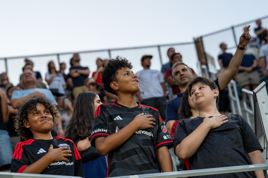 Young fans stand for the National Anthem